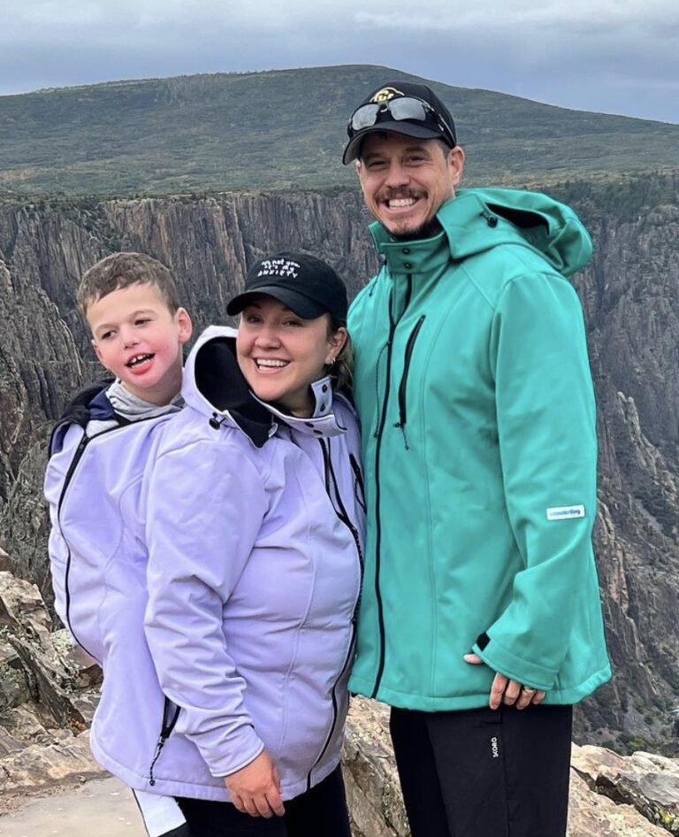 portrait of dad, mom, and son in a mountainous outdoor setting.